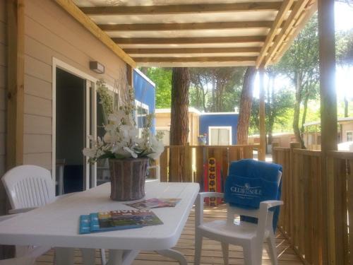 a porch with a white table and two chairs at Club del Sole Adriano Family Collection in Punta Marina