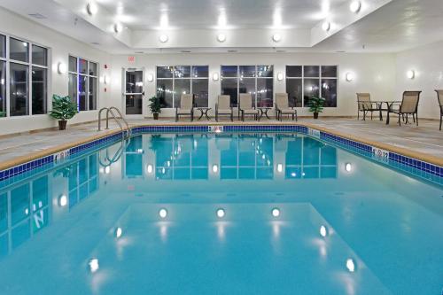 a pool at a hotel with tables and chairs at Holiday Inn Express & Suites Buffalo by IHG in Buffalo