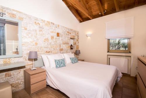a bedroom with a bed and a stone wall at Villa Lithia in Áno Korakiána