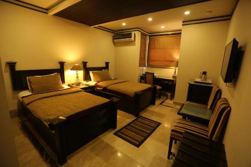 a hotel room with two beds and a television at City Centre Suites in Multan
