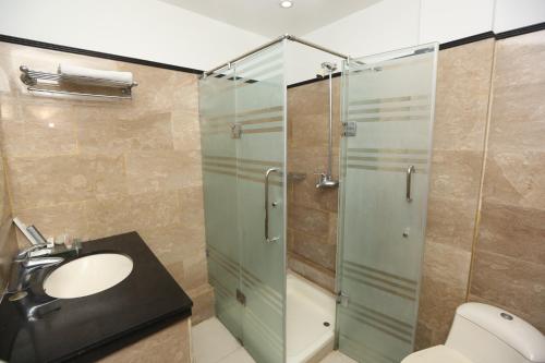 a bathroom with a glass shower and a sink at City Centre Suites in Multan