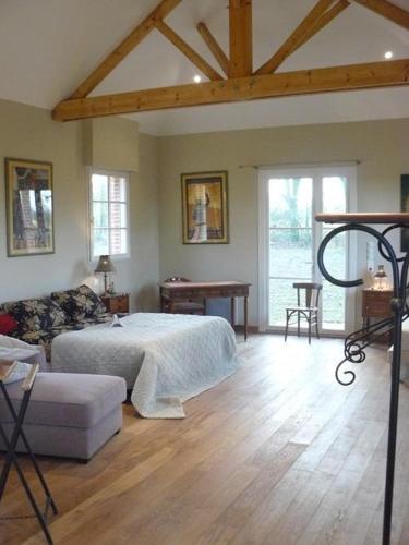 une chambre avec un lit et un canapé dans une pièce dans l'établissement Les Gîtes du Chateau de la Morinière, à Beaupréau