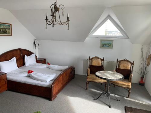 een slaapkamer met een bed en een tafel en stoelen bij Pension La Noblesse in Boekarest