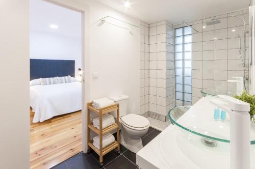 a bathroom with a toilet and a sink and a bed at AG GERMANIAS CIUDAD in Gandía