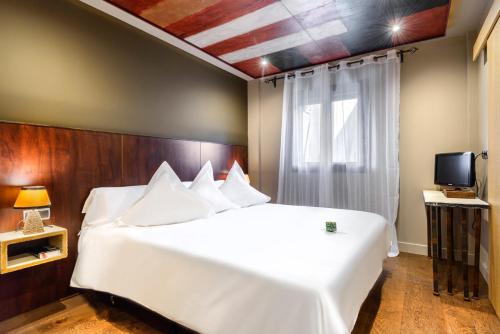 a bedroom with a large white bed and a window at Hotel La Casueña in Lanuza