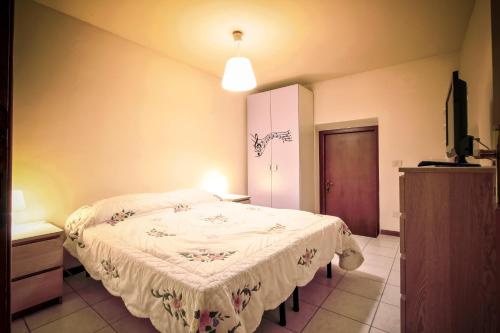 una camera da letto con un letto con una coperta bianca di Colombare Suite - Italian Homing a Sirmione