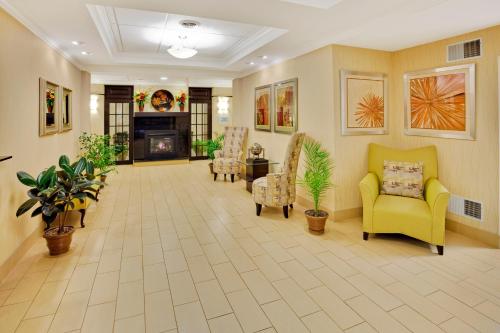 a living room with yellow chairs and a fireplace at Holiday Inn Express Hotel & Suites Lebanon by IHG in Lebanon