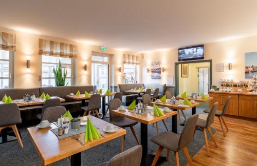 a restaurant with tables and chairs and a bar at Nordsee-Hotel Hinrichsen in Husum