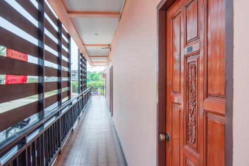 a corridor with a wooden door at OYO 628 Dao Krajang in Phetchaburi