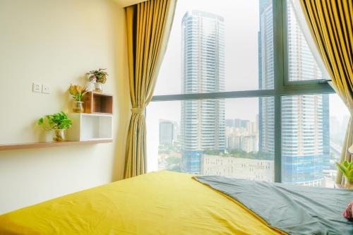 a bedroom with a yellow bed and a large window at Vinhome Skylake 2 in Hanoi
