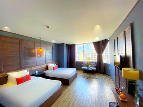 a hotel room with two beds and a television at The Light Hotel in Nha Trang