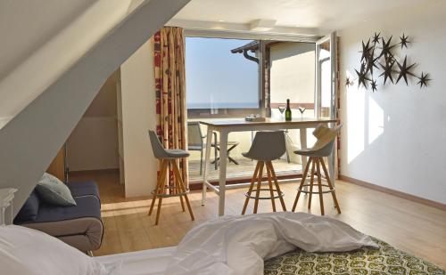 une chambre avec un lit et une table avec des chaises dans l'établissement Hotel Bellevue, à Villerville