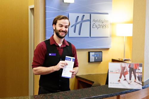 a man is standing at a counter holding a piece of paper at Holiday Inn Express & Suites Harrisburg West in Mechanicsburg