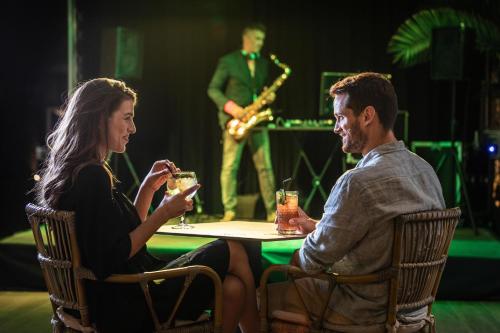 un hombre y una mujer sentados en una mesa con bebidas en JS Yate, en Can Picafort