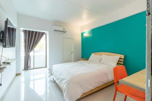 ein Schlafzimmer mit einem Bett und einer blauen Wand in der Unterkunft Living Naraa Place in Bangkok