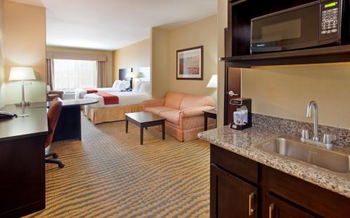 a hotel room with a kitchen and a bedroom at Holiday Inn Express & Suites Gallup East by IHG in Gallup