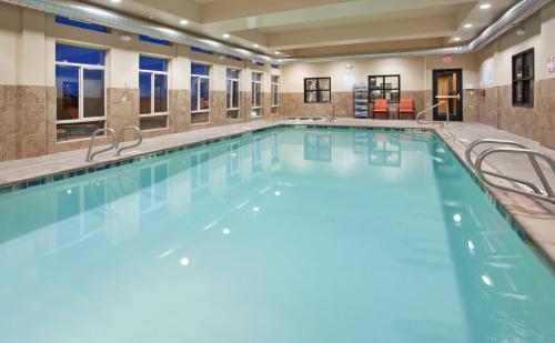 a large indoor pool with blue water in a building at Holiday Inn Express & Suites Gallup East by IHG in Gallup