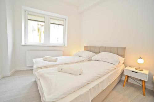 two beds in a white room with a window at Aparment near Monte Cassino by Grand Apartments in Sopot