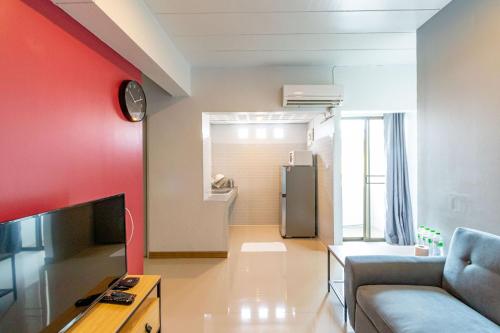 a living room with a couch and a red wall at Living Naraa Place in Bangkok