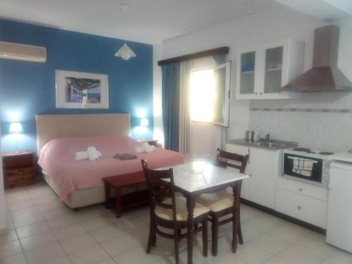 a bedroom with a bed and a table and a kitchen at Cristal Studios in Z&oacute;la