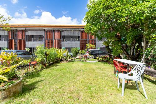 a garden with a table and a chair in front of a building at CS Klongtoey Grand Resort in Ban Yep Chaeng