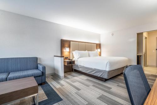 um quarto de hotel com uma cama e um sofá em Holiday Inn Express & Suites Platteville, an IHG Hotel em Platteville