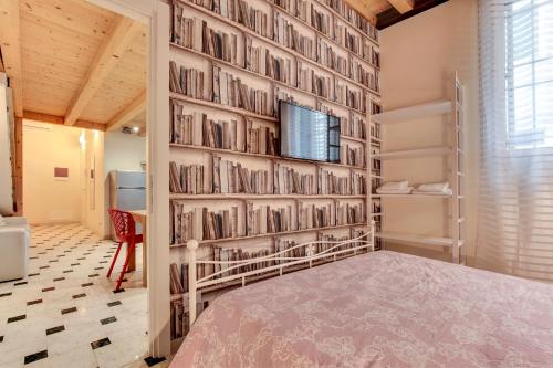 sypialnia ze ścianą wypełnioną książkami w obiekcie Arsenale Loft - Biennale w Wenecji