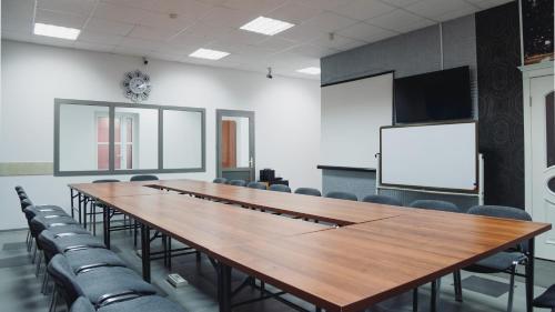 a conference room with a large wooden table and chairs at Aktobe Hotel in Aktobe