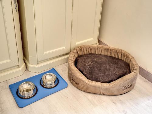 a dog bed and two bowls on a floor at Hotel Labelle in Rome