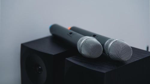 two microphones sitting on top of a black speaker at Aktobe Hotel in Aktobe