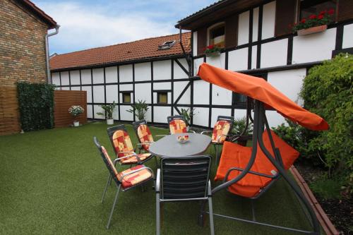 eine Terrasse mit einem Tisch und Stühlen sowie ein Gebäude in der Unterkunft Pension Thaler Hof in Thale