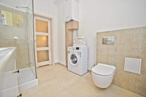 a bathroom with a washing machine and a toilet at Family apartment 50 m from Monte Cassino by Grand Apartments in Sopot