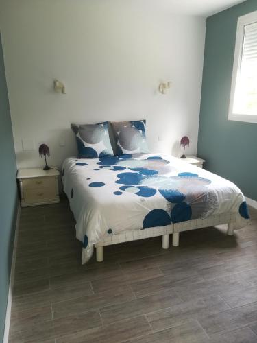 佩薩克的住宿－La KLEMALINE，一间卧室配有一张带蓝色和白色棉被的床