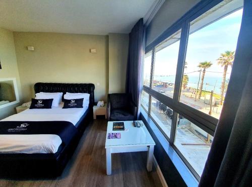 a hotel room with a bed and a view of the ocean at Spat Beach in Bat Yam