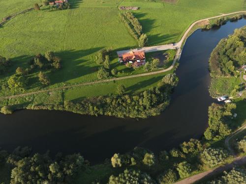 an aerial view of a house on a farm next to a lake at Rusne Villa in Rusnė