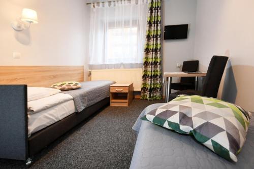 ein Hotelzimmer mit 2 Betten und einem Schreibtisch in der Unterkunft Fotex in Ząbki