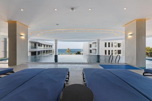 a room with two blue tables and a swimming pool at Sunset Beach Resort and Spa in Phu Quoc