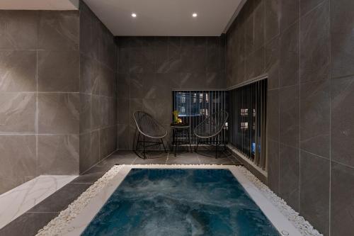 a bath tub in a room with a large tile wall at Sunset Beach Resort and Spa in Phu Quoc