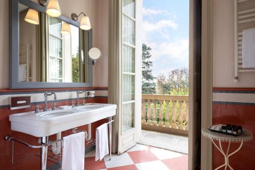 a bathroom with a sink and a large window at Sina Villa Matilde in Romano Canavese