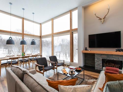 a living room with a couch and a fireplace at Chalet Ukiyo in Niseko