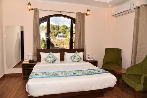 a bedroom with a large bed and a window at Mastiff Wildcrest Outer Dharamshala Near Chamunda Devi Temple in Pālampur