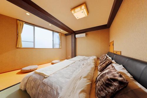 Cama grande en habitación con ventana en Terrace Terano#101 en Tokio