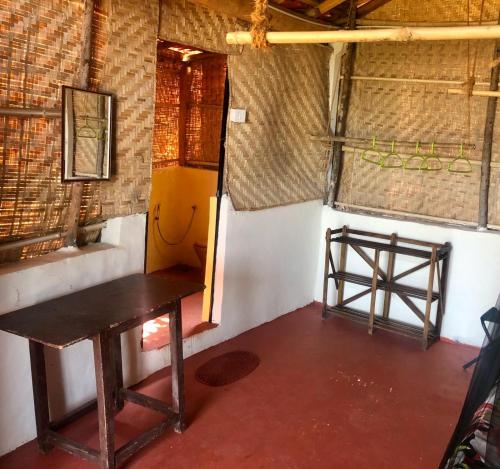a room with a wooden table and a door at Sweet Valley Cottages in Arambol
