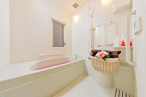 uma casa de banho com uma banheira, um lavatório e um espelho. em Terrace Terano#101 em Tóquio