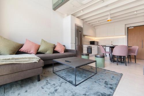 a living room with a couch and a table at 117 on Strand - Luxury Apartments in Cape Town