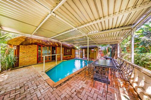 a house with a swimming pool with a table at Amper Bo Guest House in Pretoria
