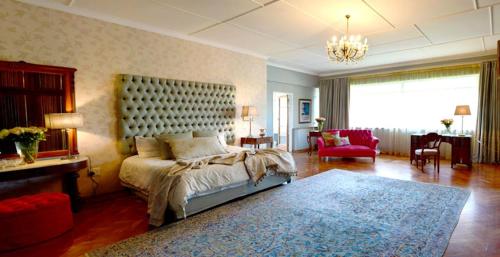 a bedroom with a large bed and a living room at THE WHITE HOUSE in Johannesburg