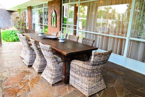 een houten tafel en stoelen op een patio bij THE WHITE HOUSE in Johannesburg