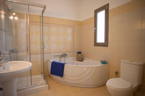 łazienka z wanną, toaletą i umywalką w obiekcie Villa Helios w mieście Spartia
