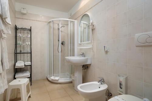 uma casa de banho com um chuveiro, um WC e um lavatório. em Hotel Due Mari em Sestri Levante